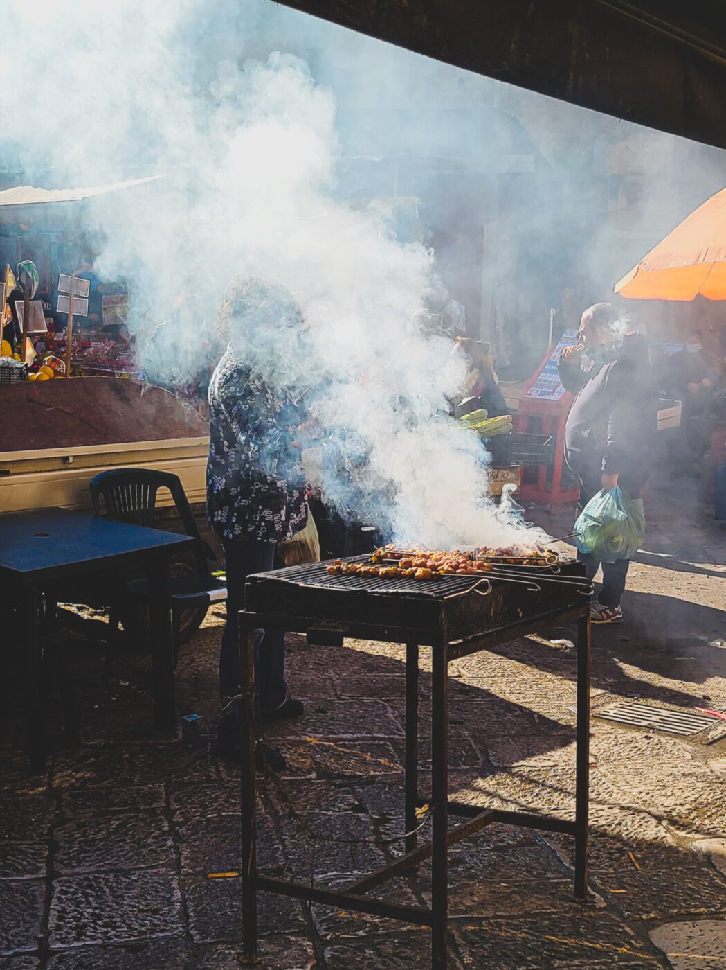 Smoke billowing from a barbecue at a food market in Palermo, Sicily