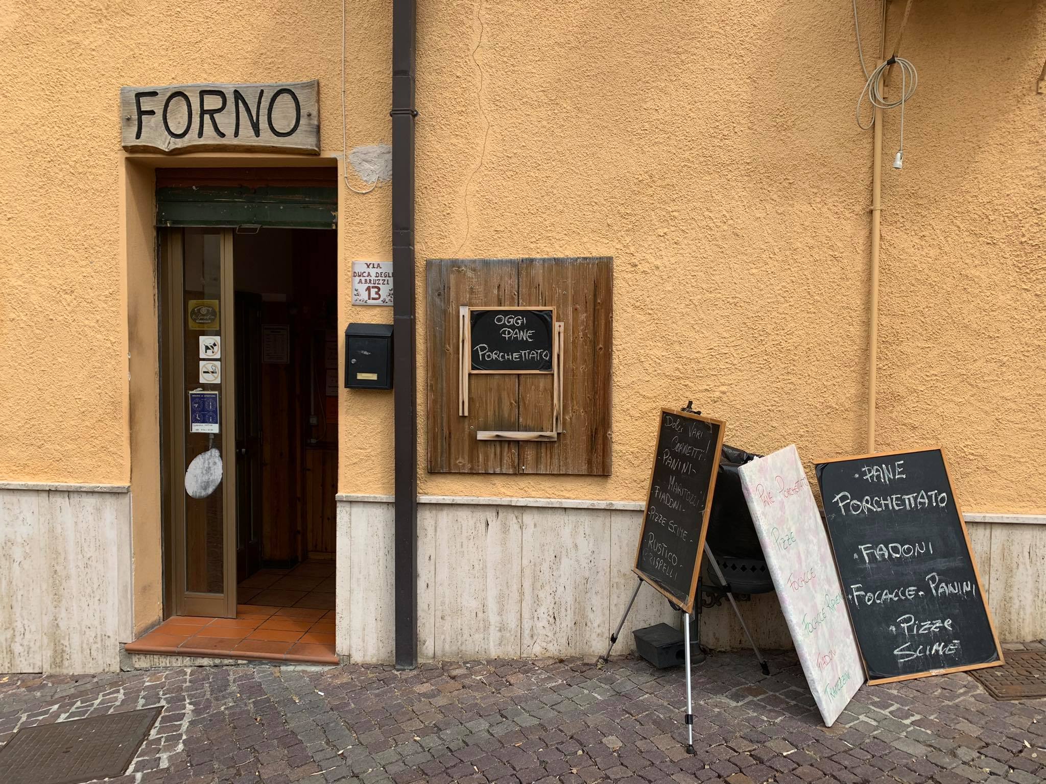 Typical italian forno restaurant with salmon colored wall and charcoal boards with menu in abruzzo Italy