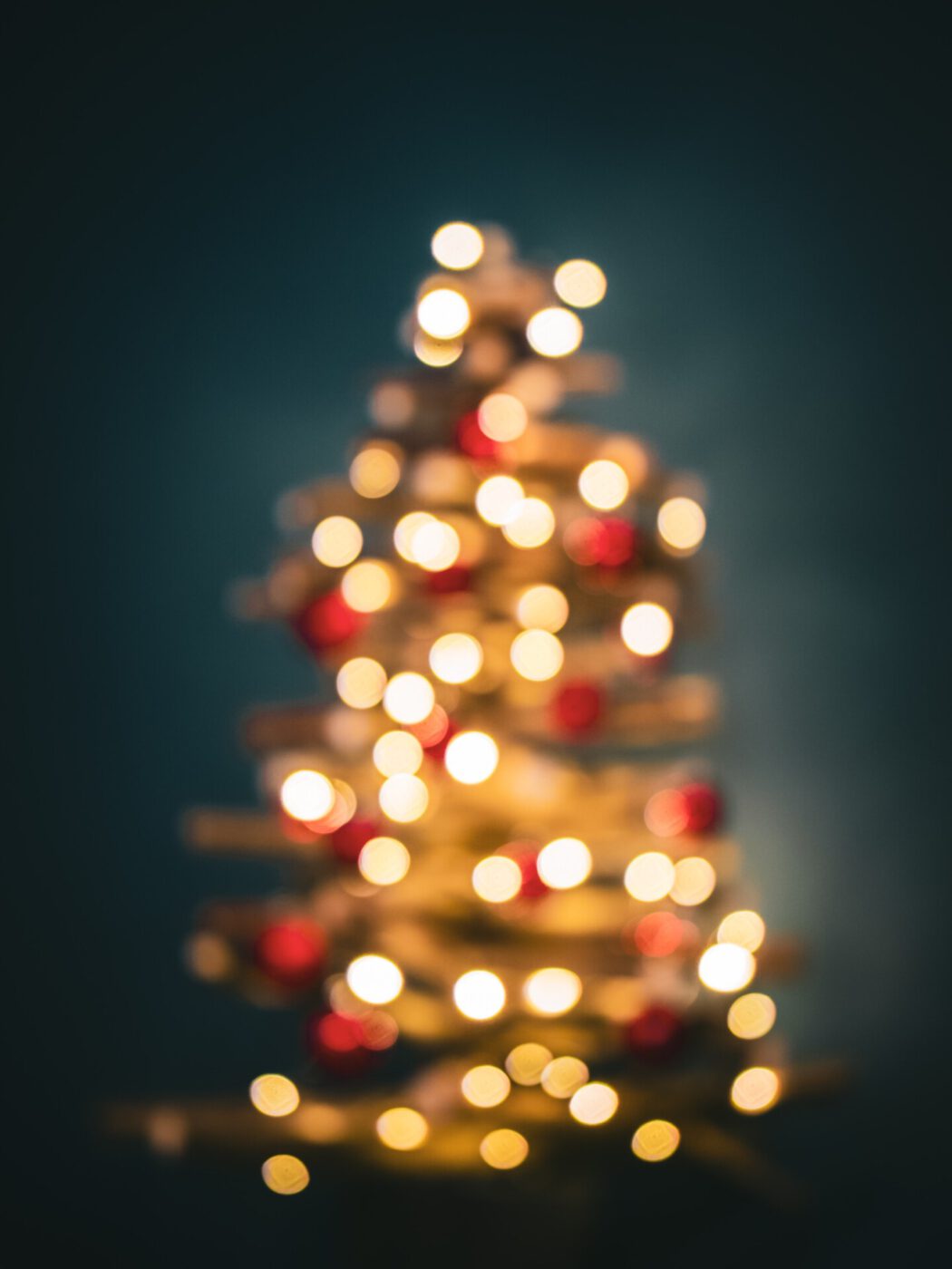 Blurred christmas tree filled up with lights and red balls