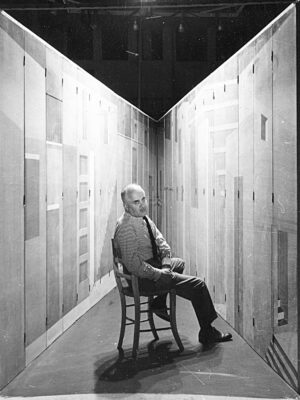 Photograph of the Italian artist Piero Fornasetti sitting in his La Stanza Metafisica