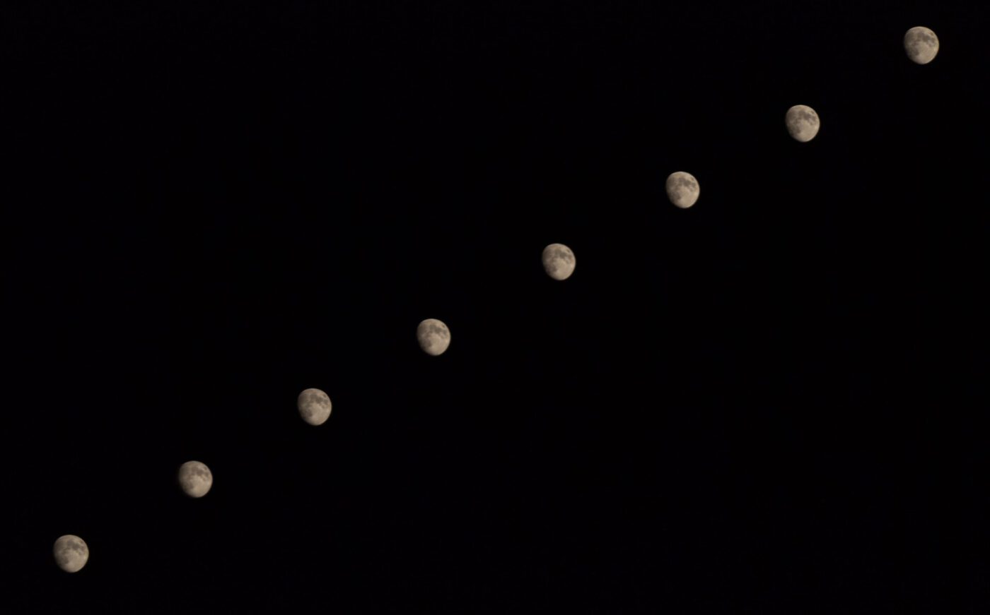 moons in diagonal line on black background