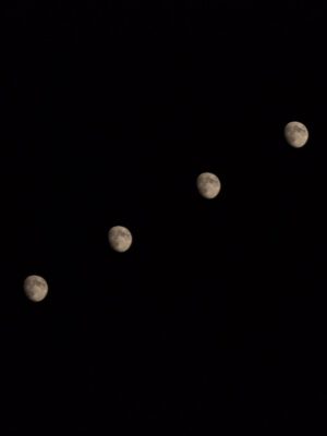 moons in diagonal line on black background