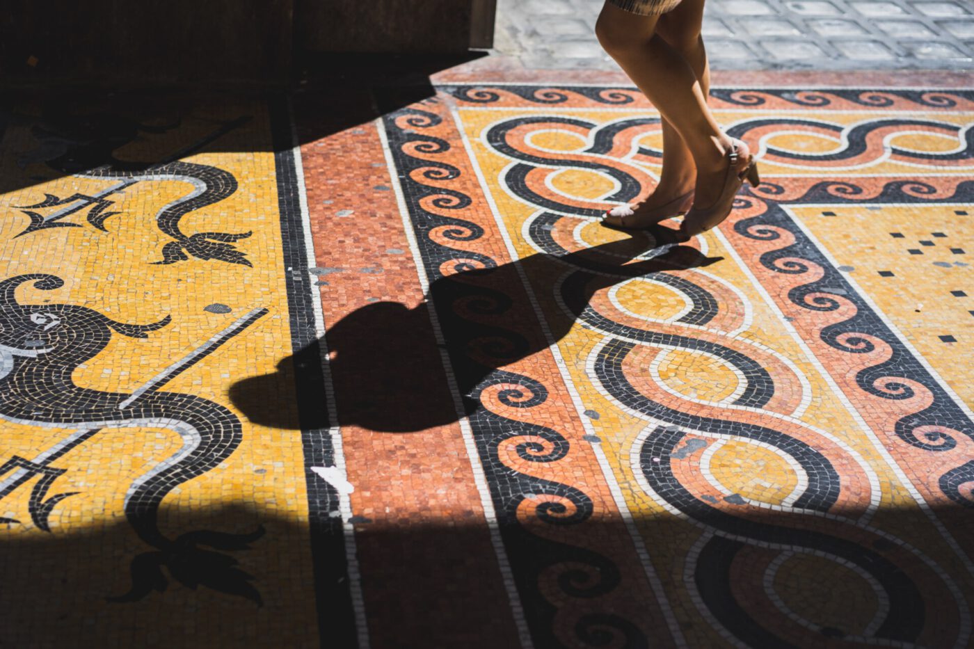 woman in heels walking across mosaic floor