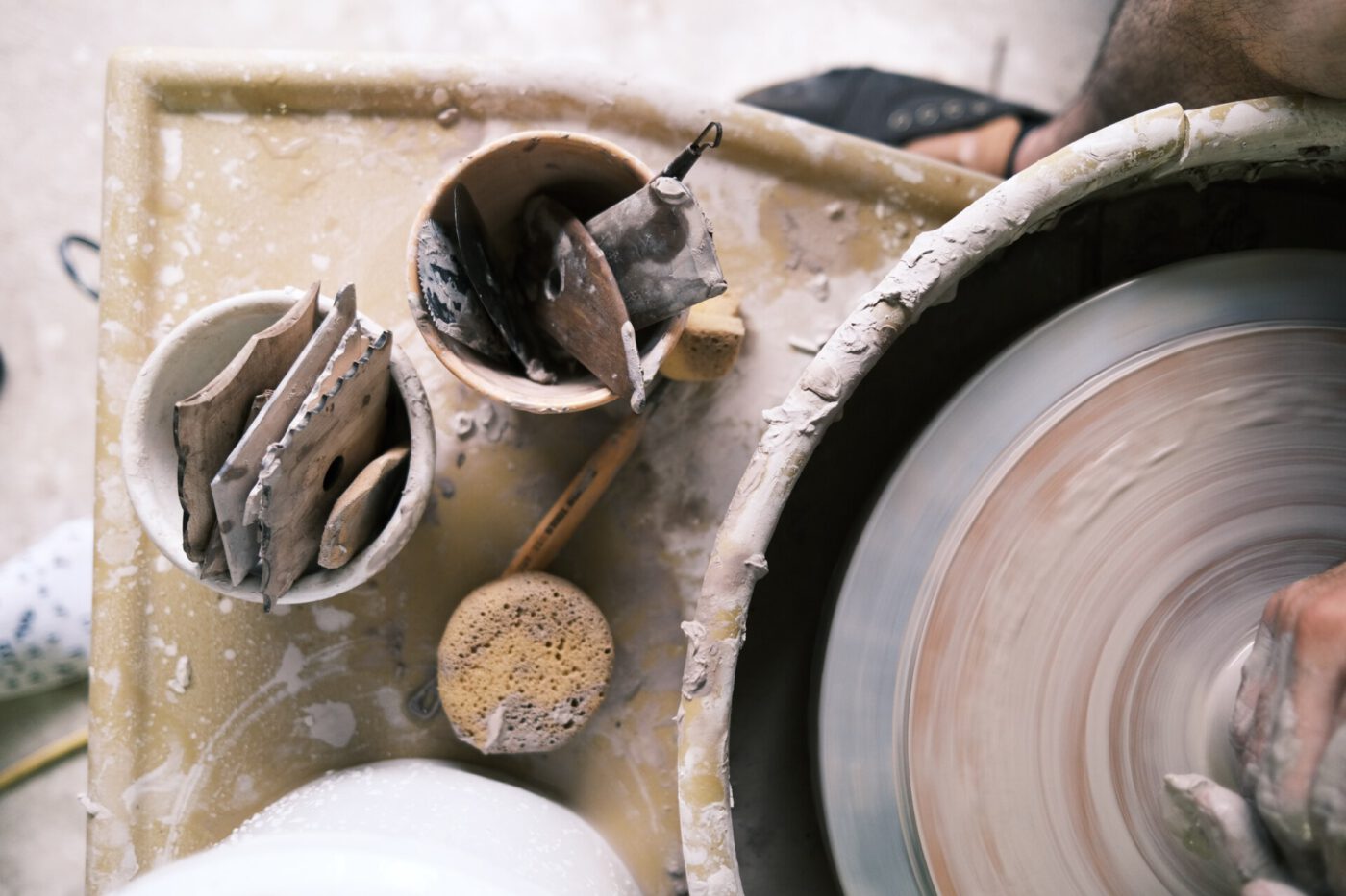 Ceramic torn with clay piece being molded and tools in Italy