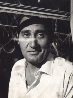 black and white photo of man looking out of a window with a white shirt