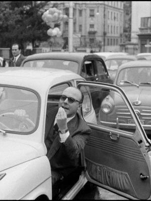 an Italian man gesturing out of his Fiat door in frustration of the terrible traffic