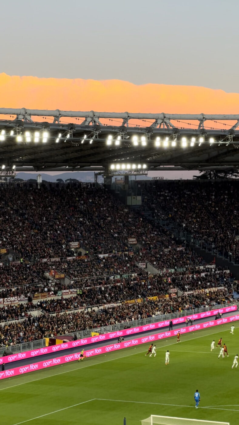photo of an Italian football stadium at sunset filled with spectators