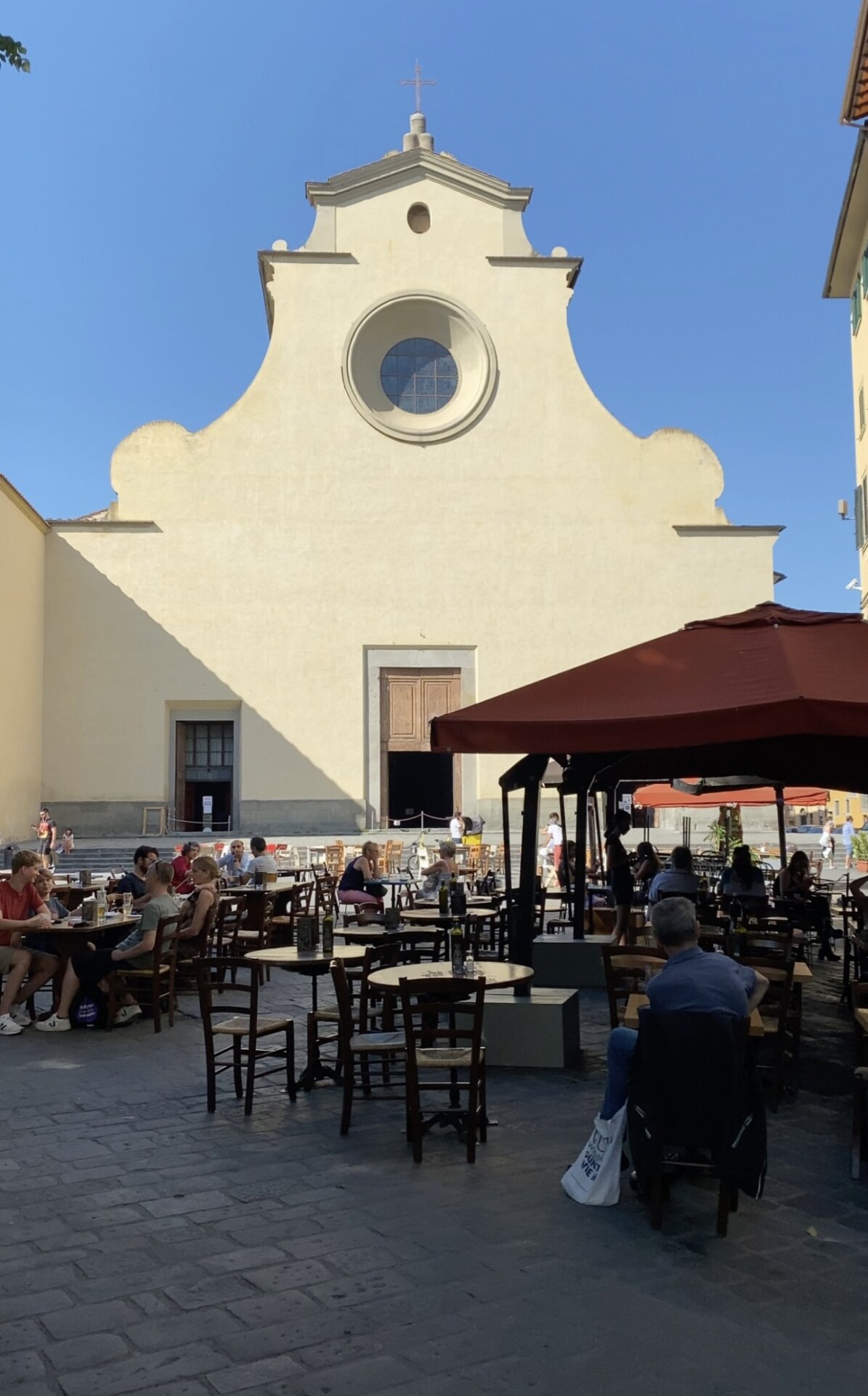 people sitting at tables in Piazza Santo Spirito in Florence