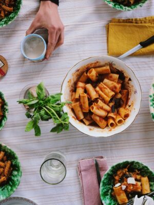 an overhead of a table with plates of pasta alla norma