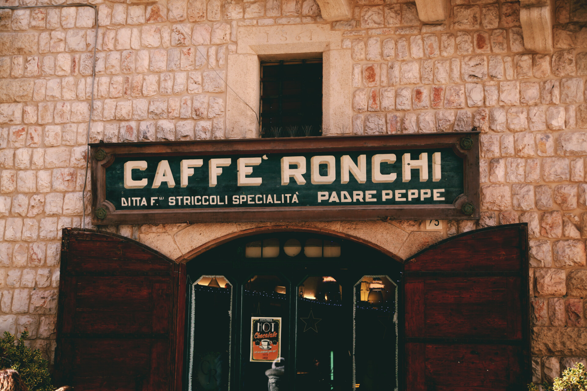 a photo of the outside of Caffe Ronchi in Altamura showing a dark green sign with the caffe's name