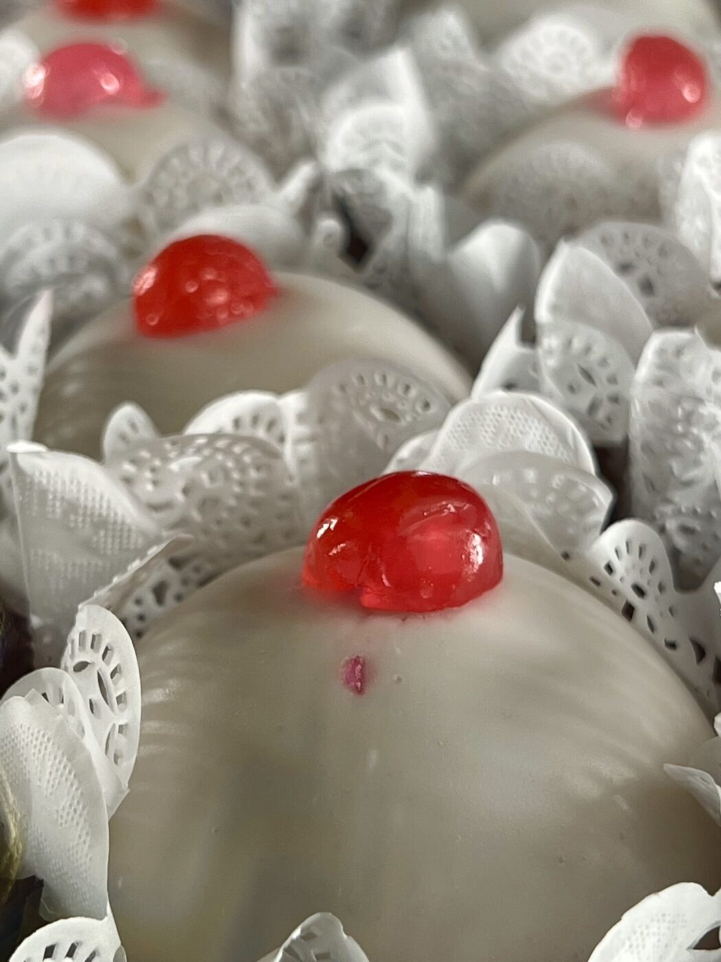 Sicilian cassata; round white pastries with half a red cherry on top