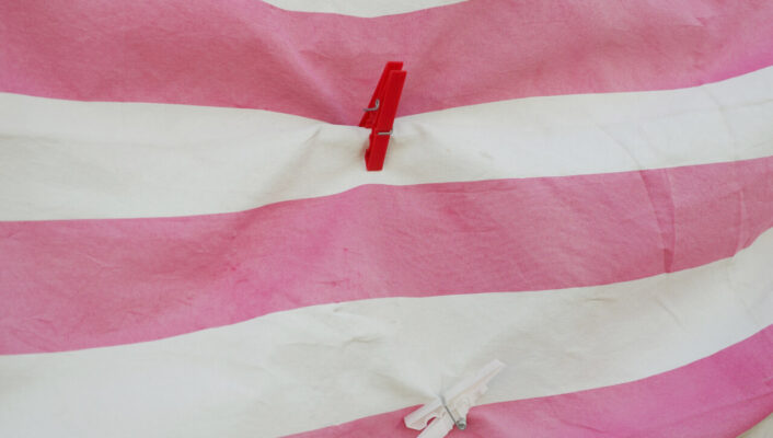 photo by Leandro Colantoni: a pink and white striped blanket with two red and white clothespins