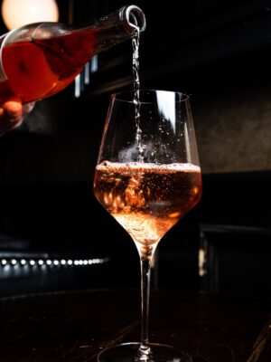 a photo of a glass ofa light colored glass of wine being poured
