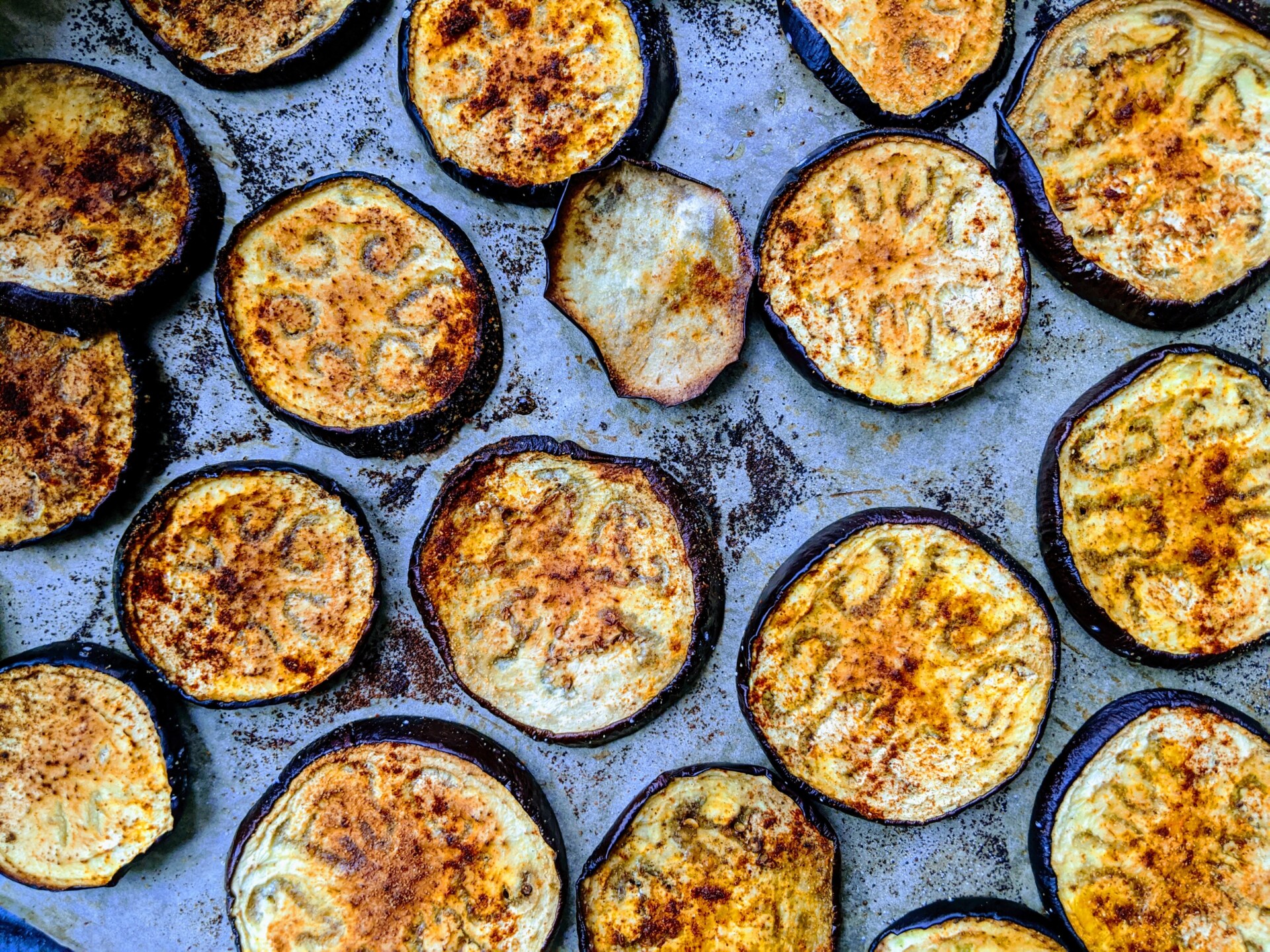 an aluminum pan with sliced rounds of roasted eggplant