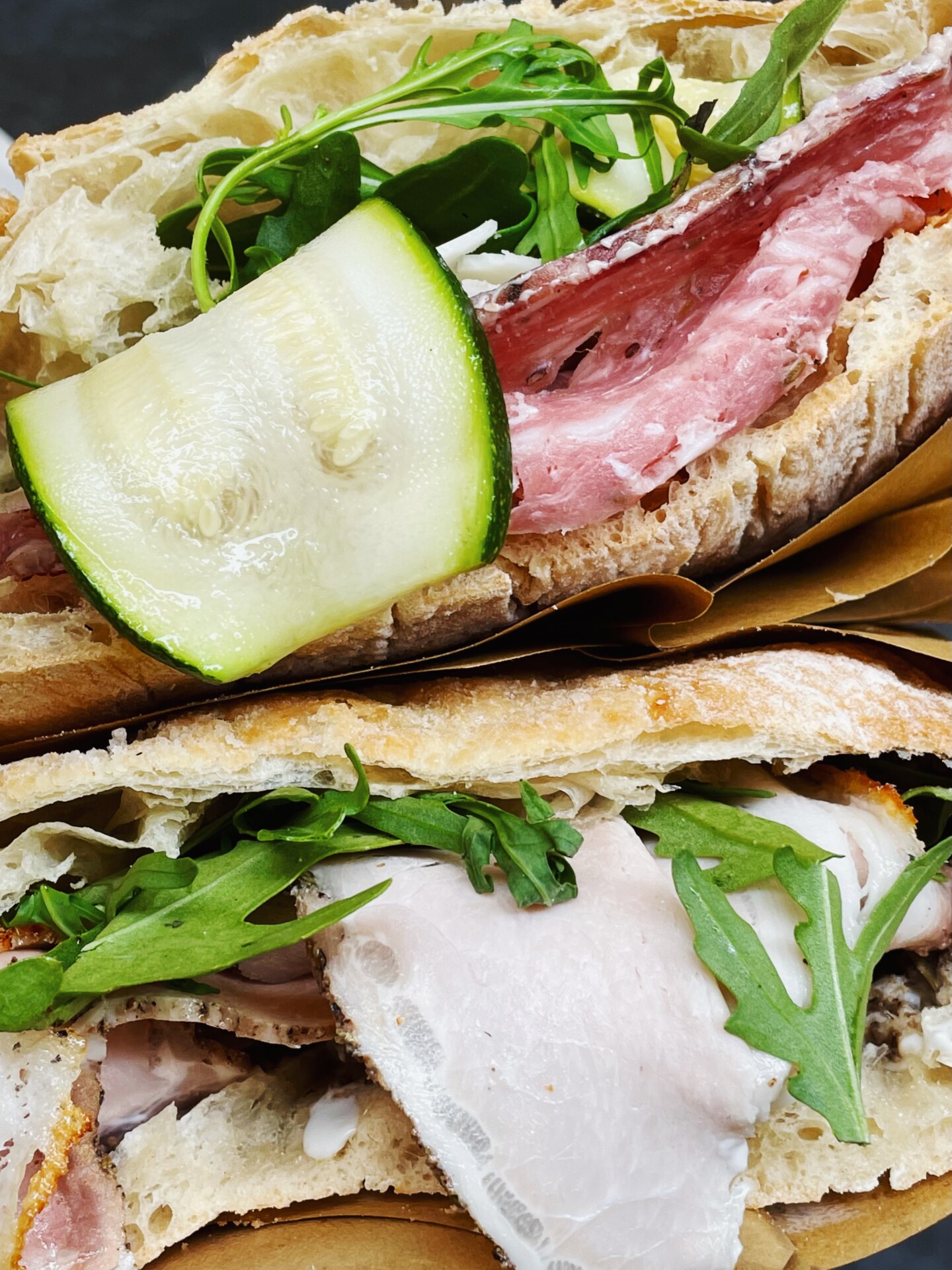 Two panini held together; both on thin, flaky bread and filled with zucchini, meat, and cheese, from I’ Girone De’ Ghiotti
