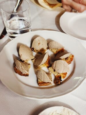 a white plate filled with Crostini con Fegatini