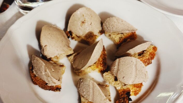 a white plate filled with Crostini con Fegatini