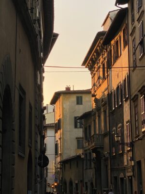 the sun setting over a Florentine street