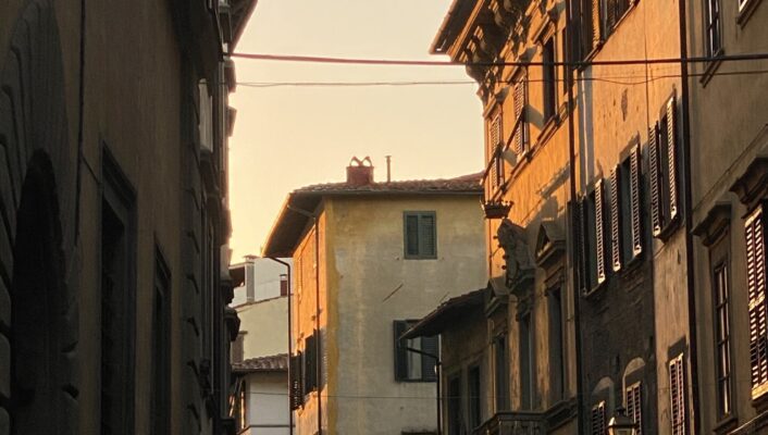 the sun setting over a Florentine street