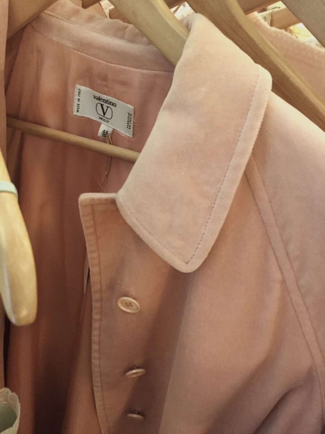 a valentino coat hanging in a vintage store