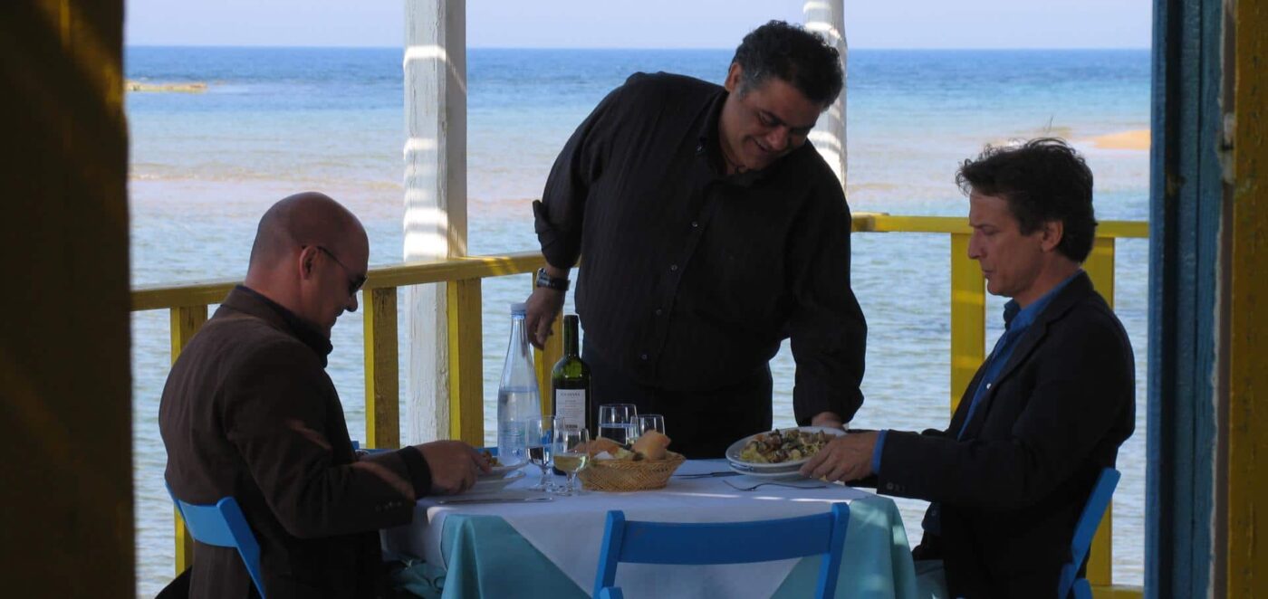 Enzo a Mare, Punta Secca, three men (one is Inspector Montalbano) at a table eating