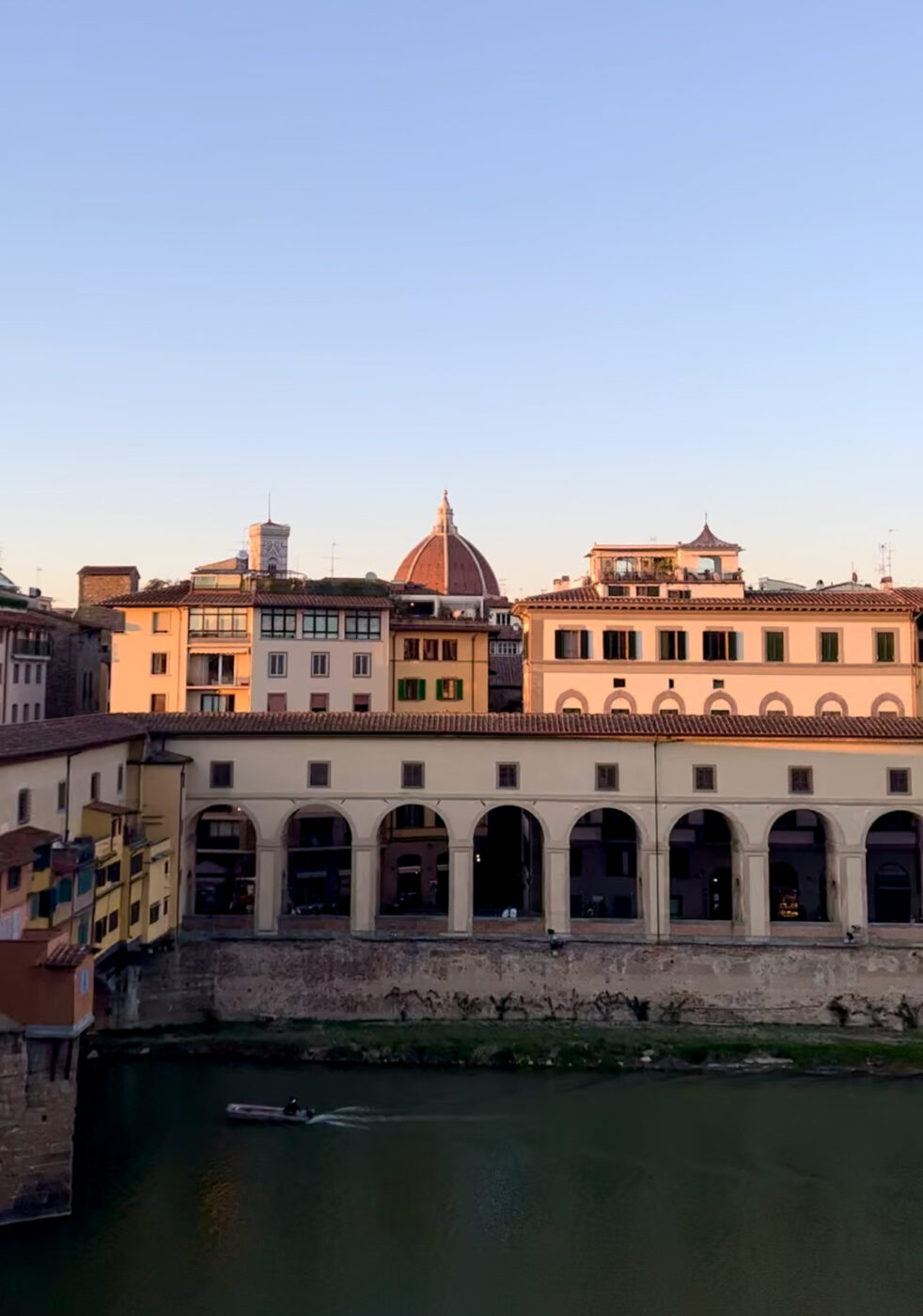 florence at sunset showing the Arno, the ponte vecchio, and the duomo poking up in the background