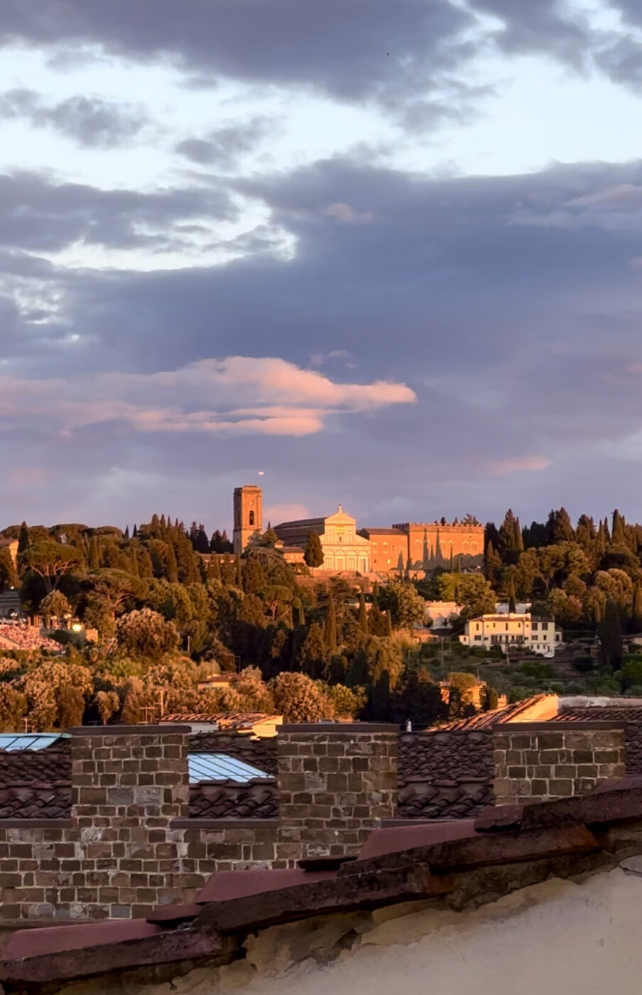 the sunset over the Arno river with the outer hills of Florence in the background