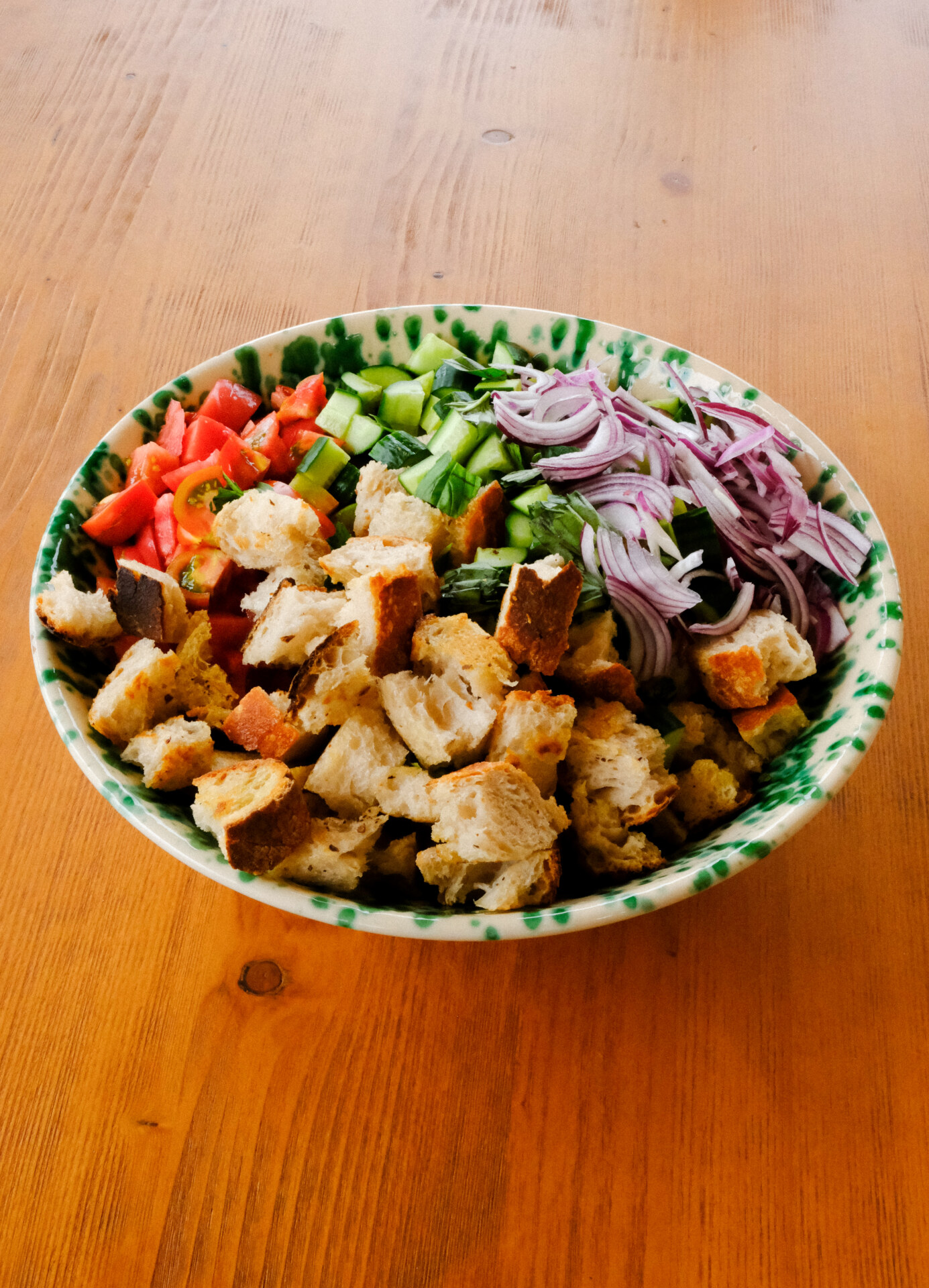a bowl of panzanella salad that hasn't been tossed together yet