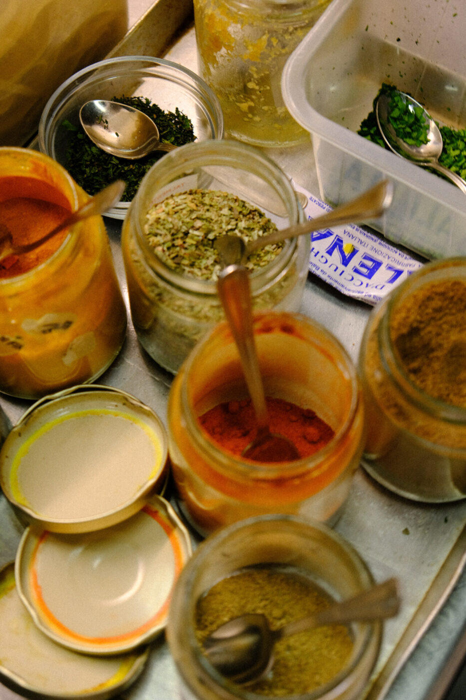 a collection of opened jars filled with spices in the kitchen at Cibreo