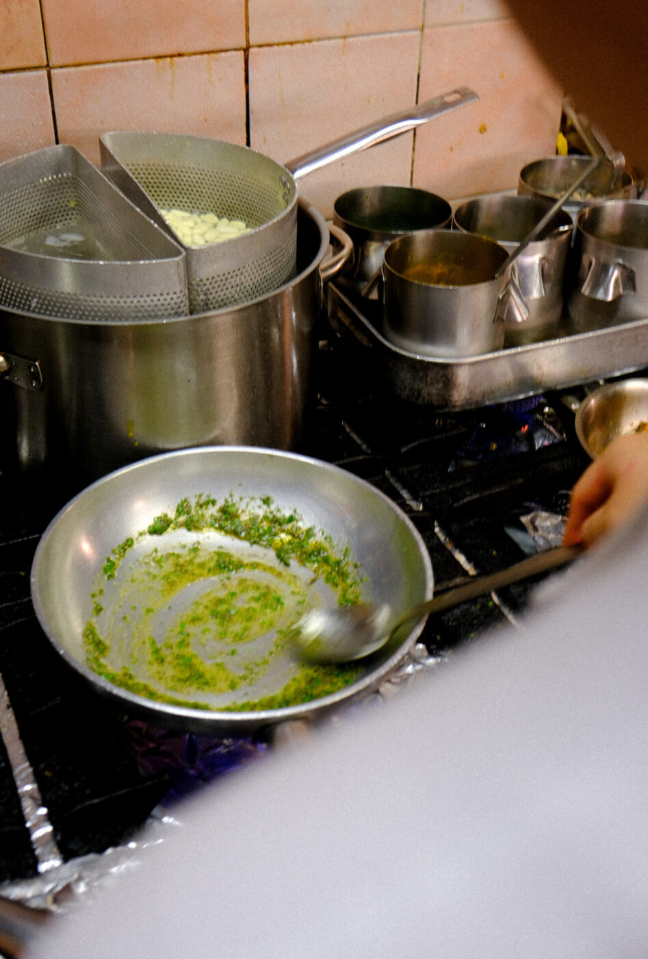 the pasta station at Cibreo with a pan of pesto and pasta boiling behind it