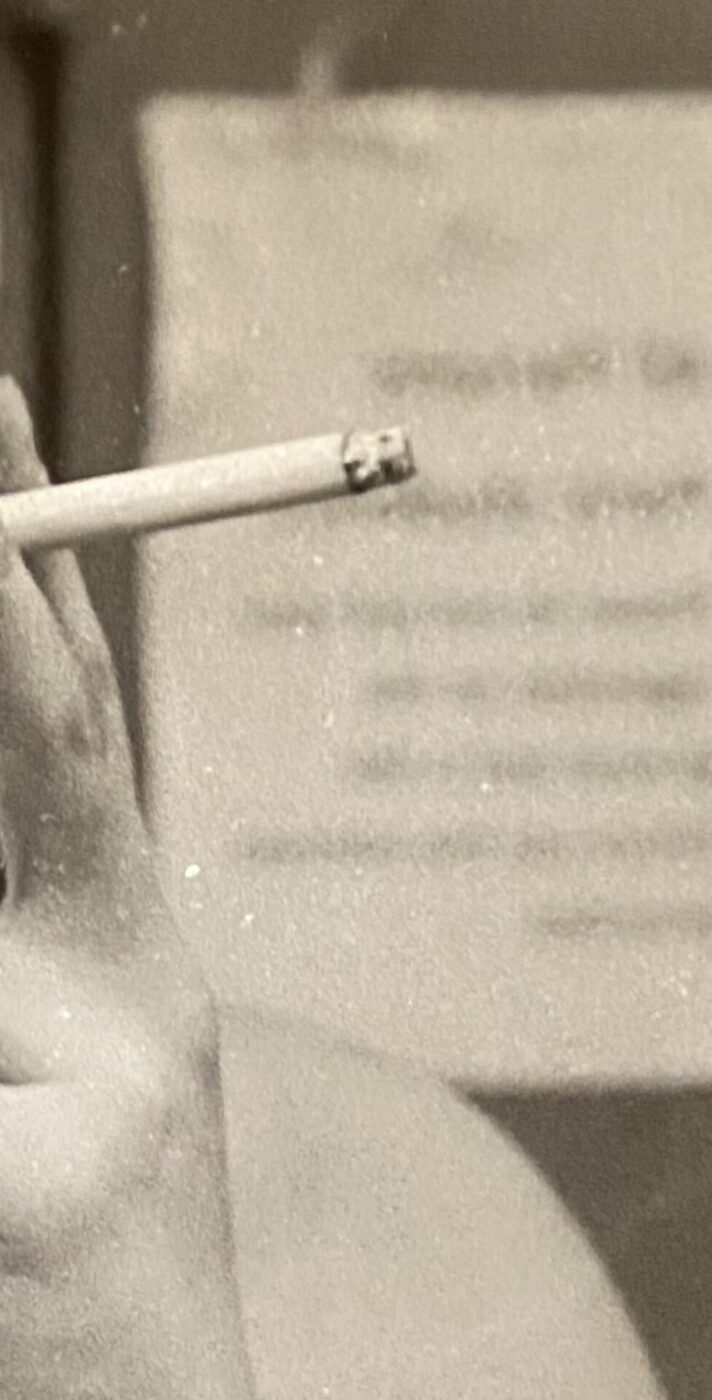 black and white photo of a woman holding a cigarette
