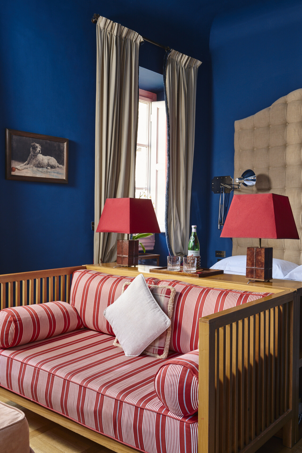 a navy room at casa howard with a red and white stripped couch