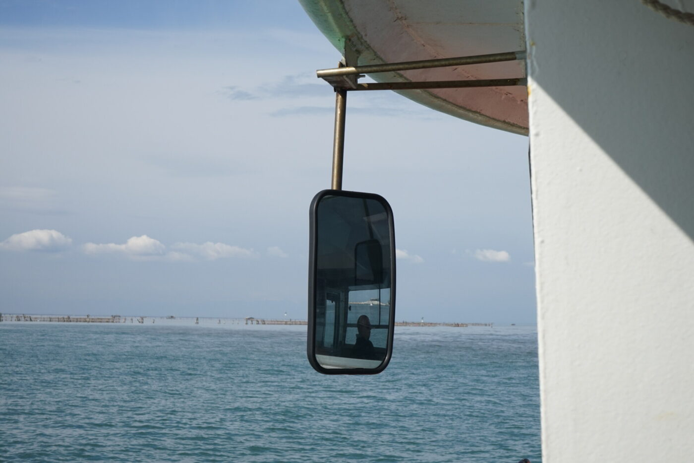 a photo of a rearview mirror on a boat off the island of Pellestrina
