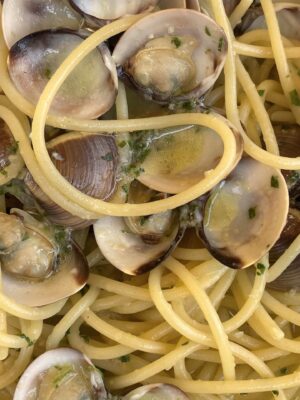 a close up image of Spaghetti alle Vongole showing clams in their shell and spaghetti wrapped around it