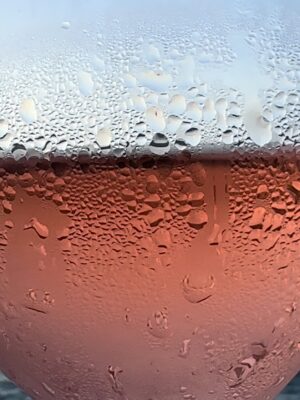 a close up of a glass of rose covered in condensation