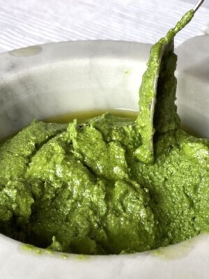 bright green pesto in a white marble container