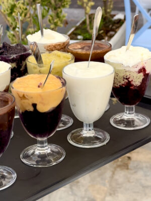 a platter with 10 different glasses of granita filled perfectly to the top with brightly colored irce