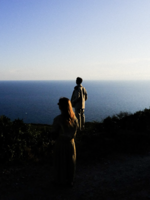 a couple standing at the edge of the sea in a very darkened photo