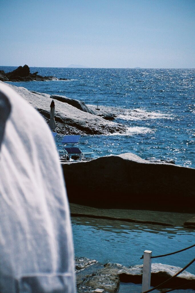 an image of the sea and large boulders along the coast