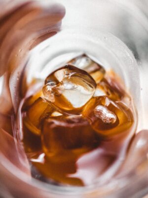 an image taken inside a glass of ice and you can barely see the distorted hang holding the glass