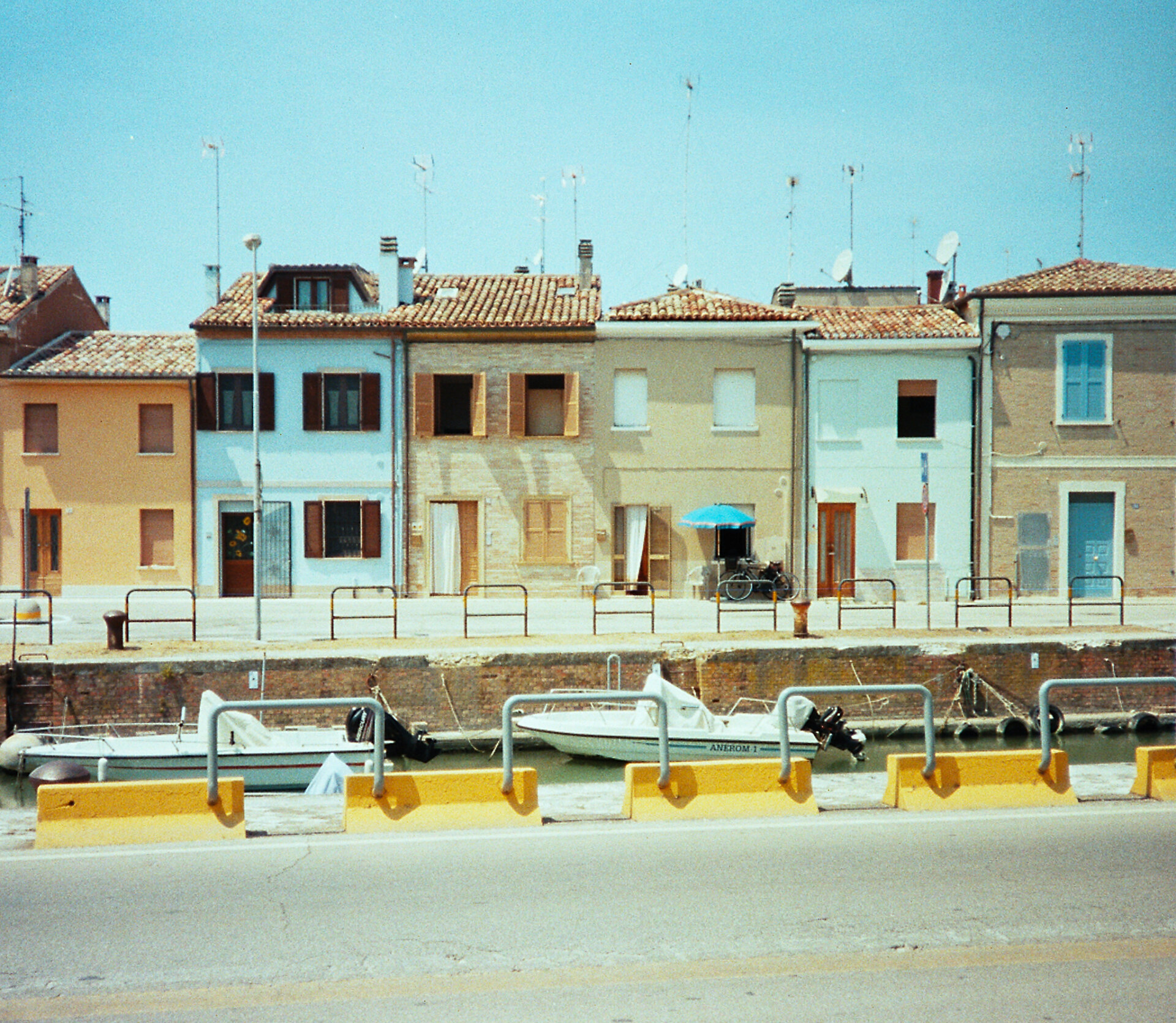 a faded image of boats in a canal against pastel colored houses