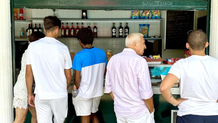 five people standing at the bar in a circolo all dressed in athletic wear