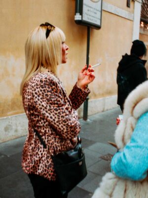 Photography by Lorenzo Gargiulo of a woman wearing a leopard coat smoking a cigarette in a piazza in Rome