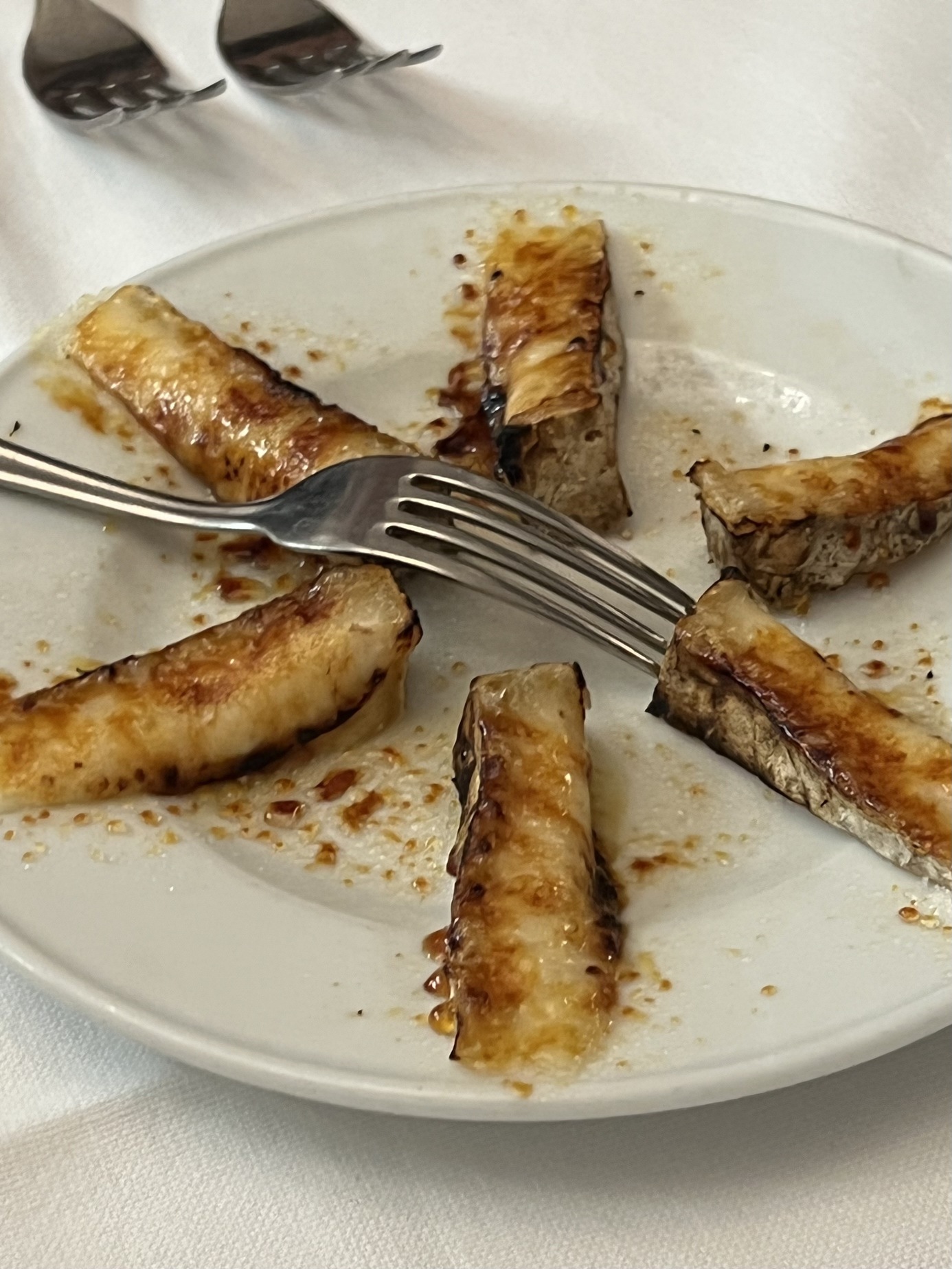 five slices of cheese arranged around a circular clear plate and burnt so the sugars crystalized on top and on the plate