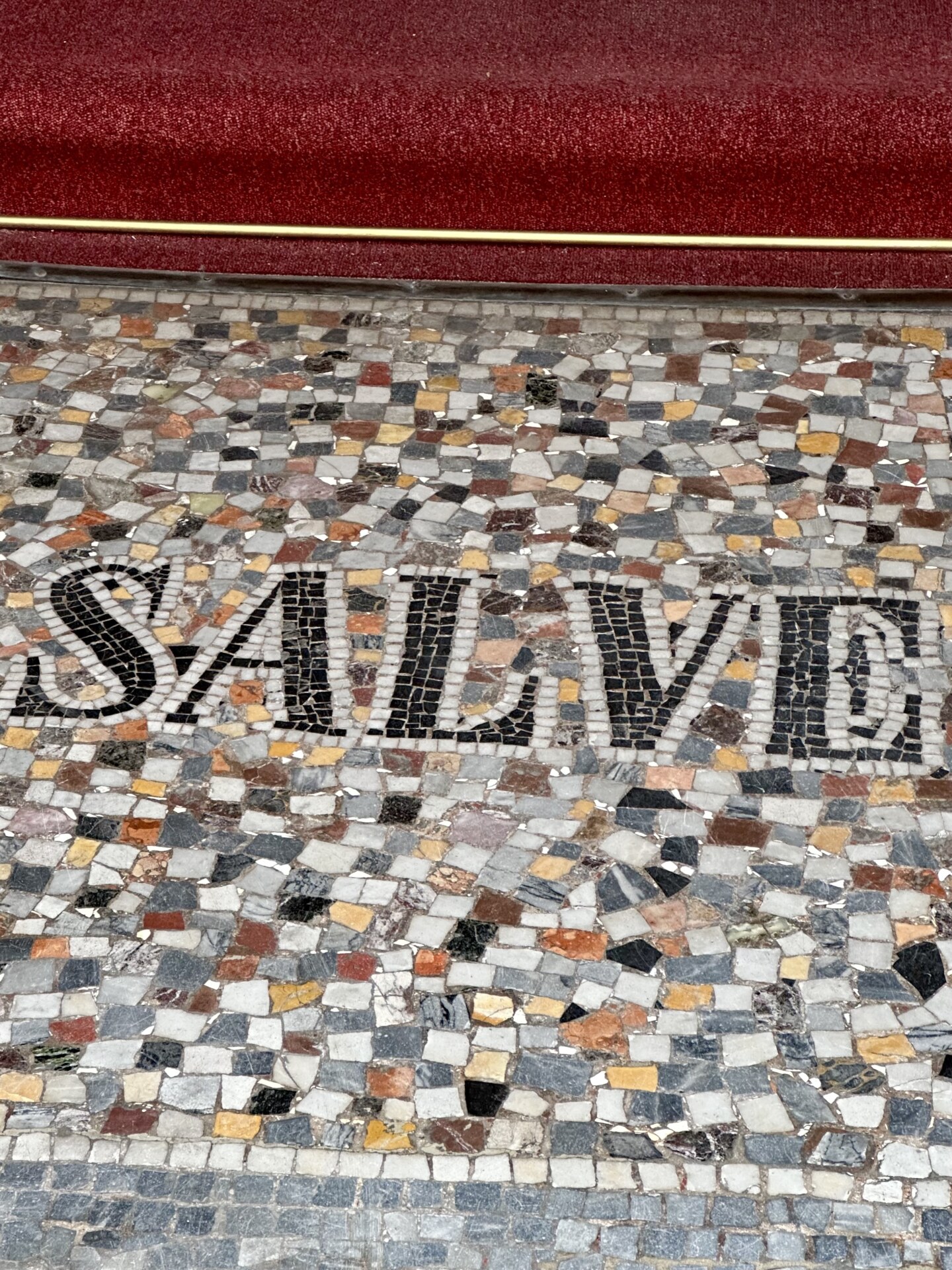 a tile sign on the ground that says "salve"