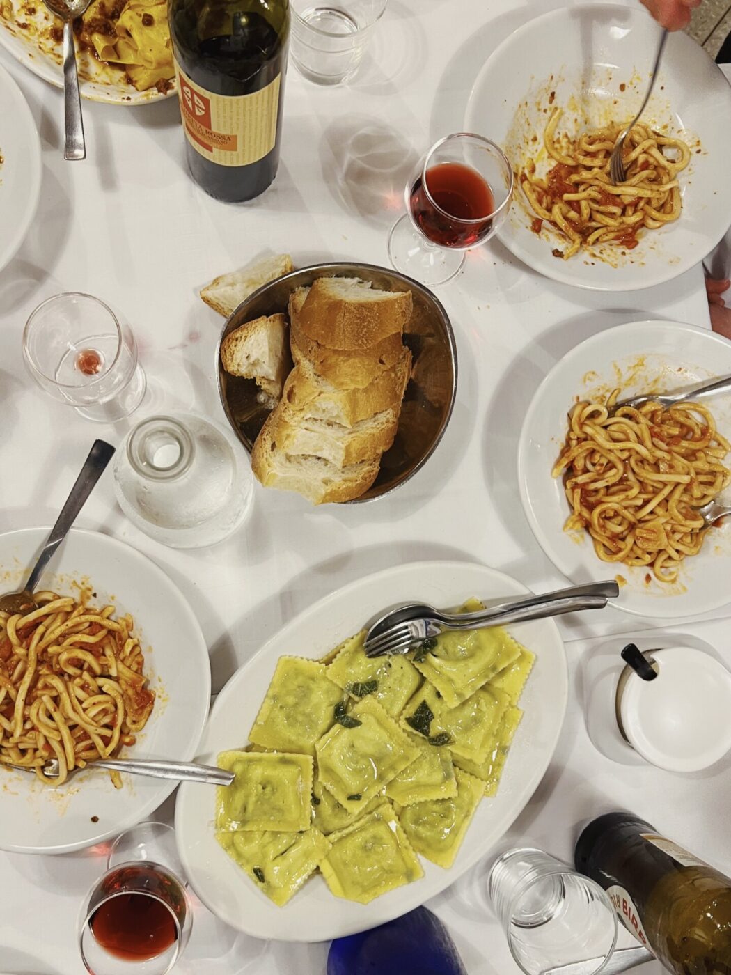 a table filled with plates of pasta including Pici all'aglione