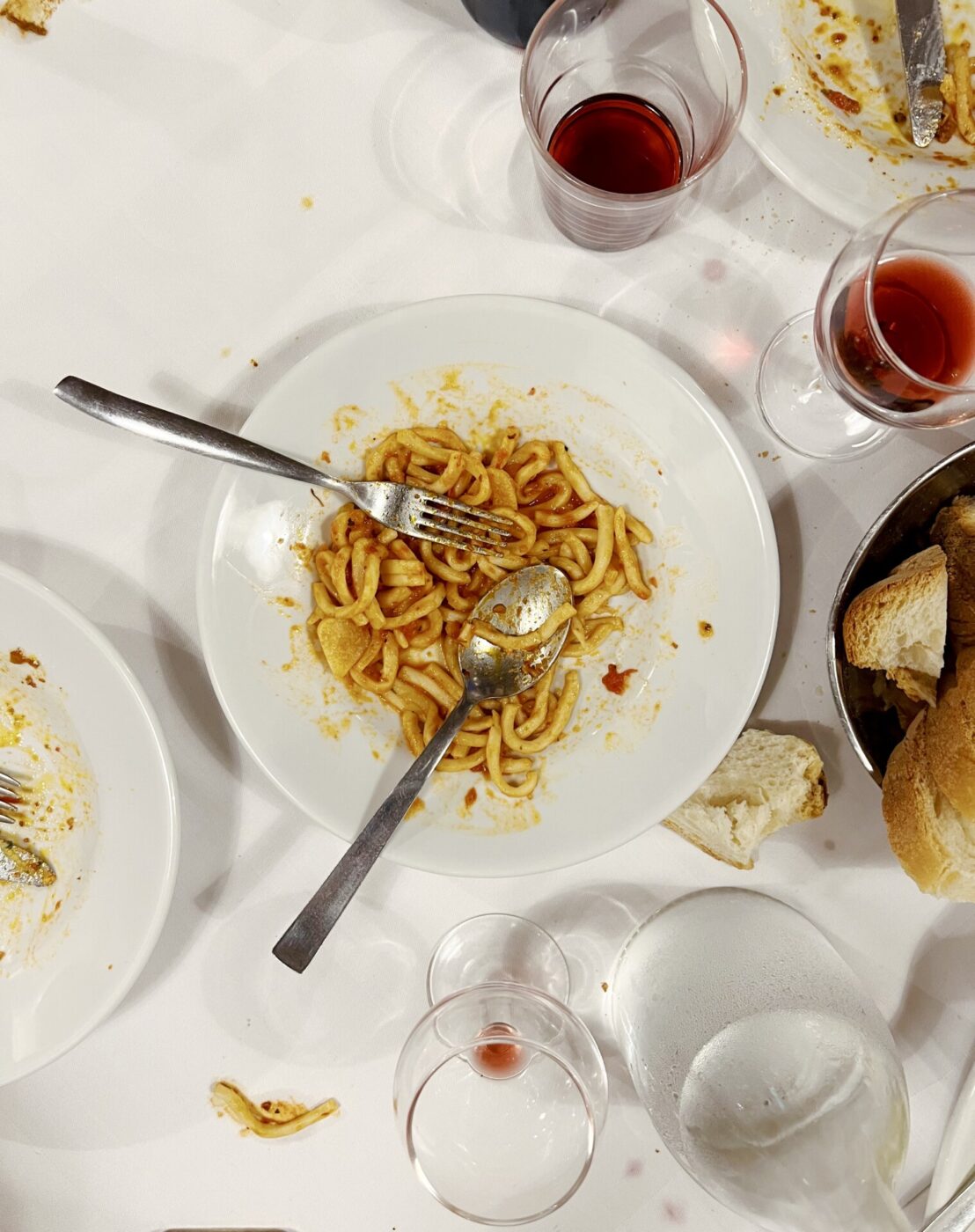 an overhead photo of a messy table with Pici all'aglione