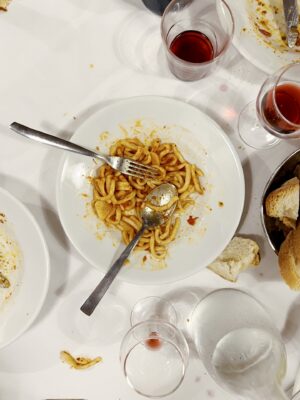 an overhead photo of a messy table with Pici all'aglione