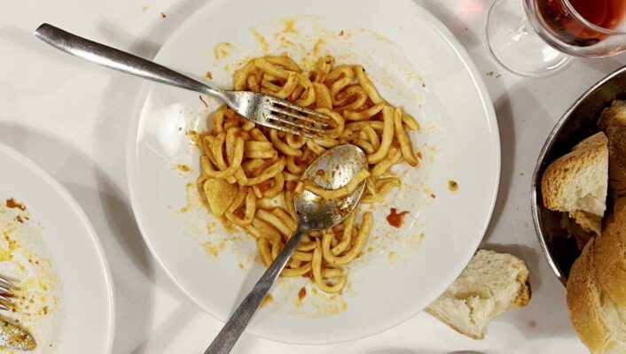 an overhead photo of a messy table with Pici all'aglione