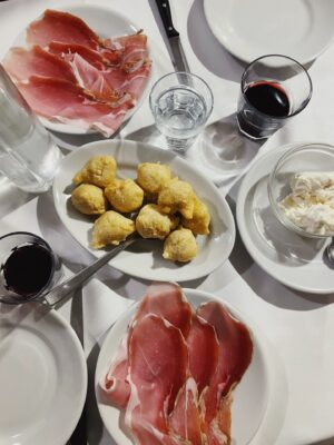 an overhead photo of plates of coccoli at Coccoli, prosciutto, and straciatella at I’Brindellone